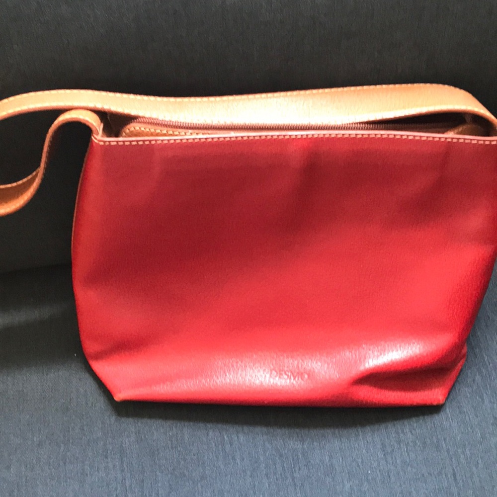 Red leather handbag with camel strap and trim